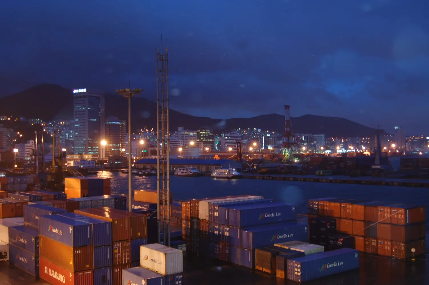 Containers and harbour facilities at Busan Port during blue hour.