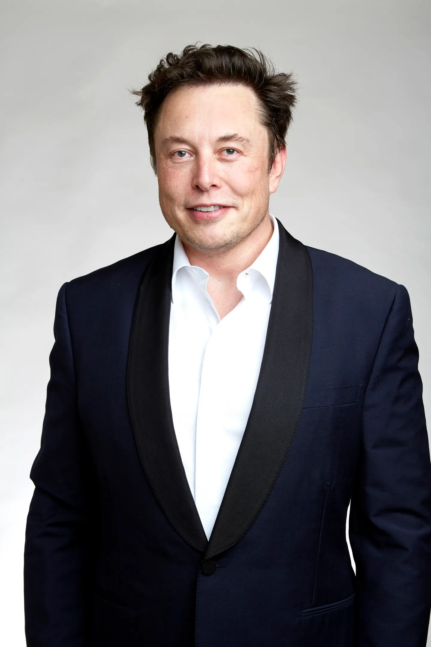 Elon Musk wearing a dark jacket and white shirt
