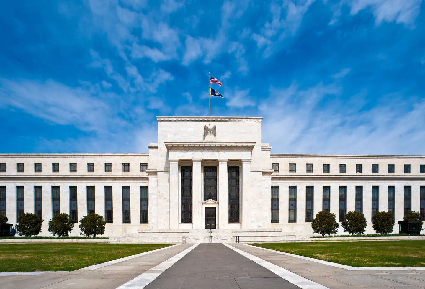 The Federal Reserve's white marble Eccles Building beneath a blue sky