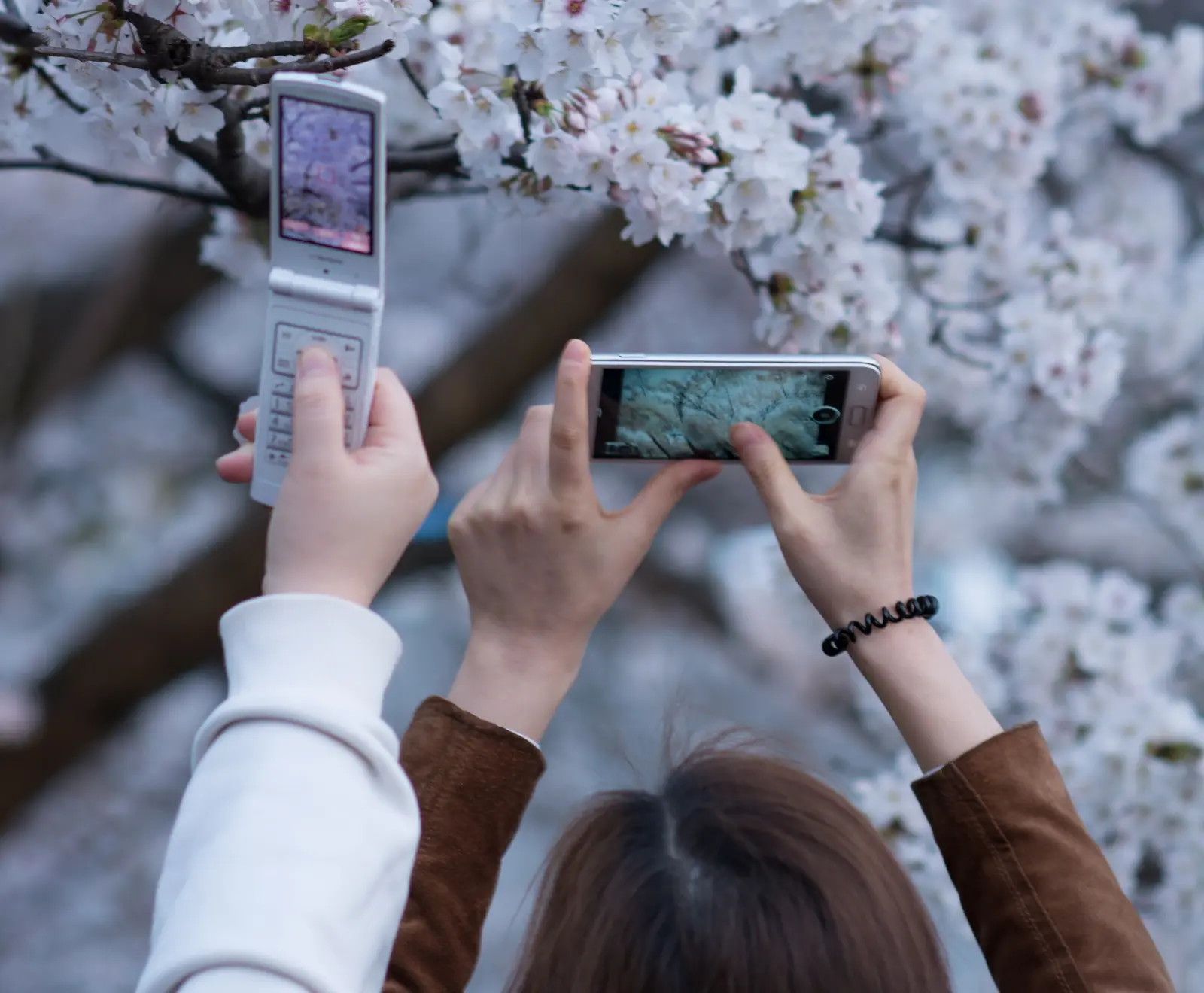 A traditional mobile phone beside a smartphone photographed in Mitaka, Tokyo.