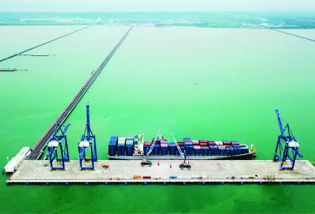 Kapal peti kemas dan derek di Terminal Multipurpose Kuala Tanjung, Sumatra Utara