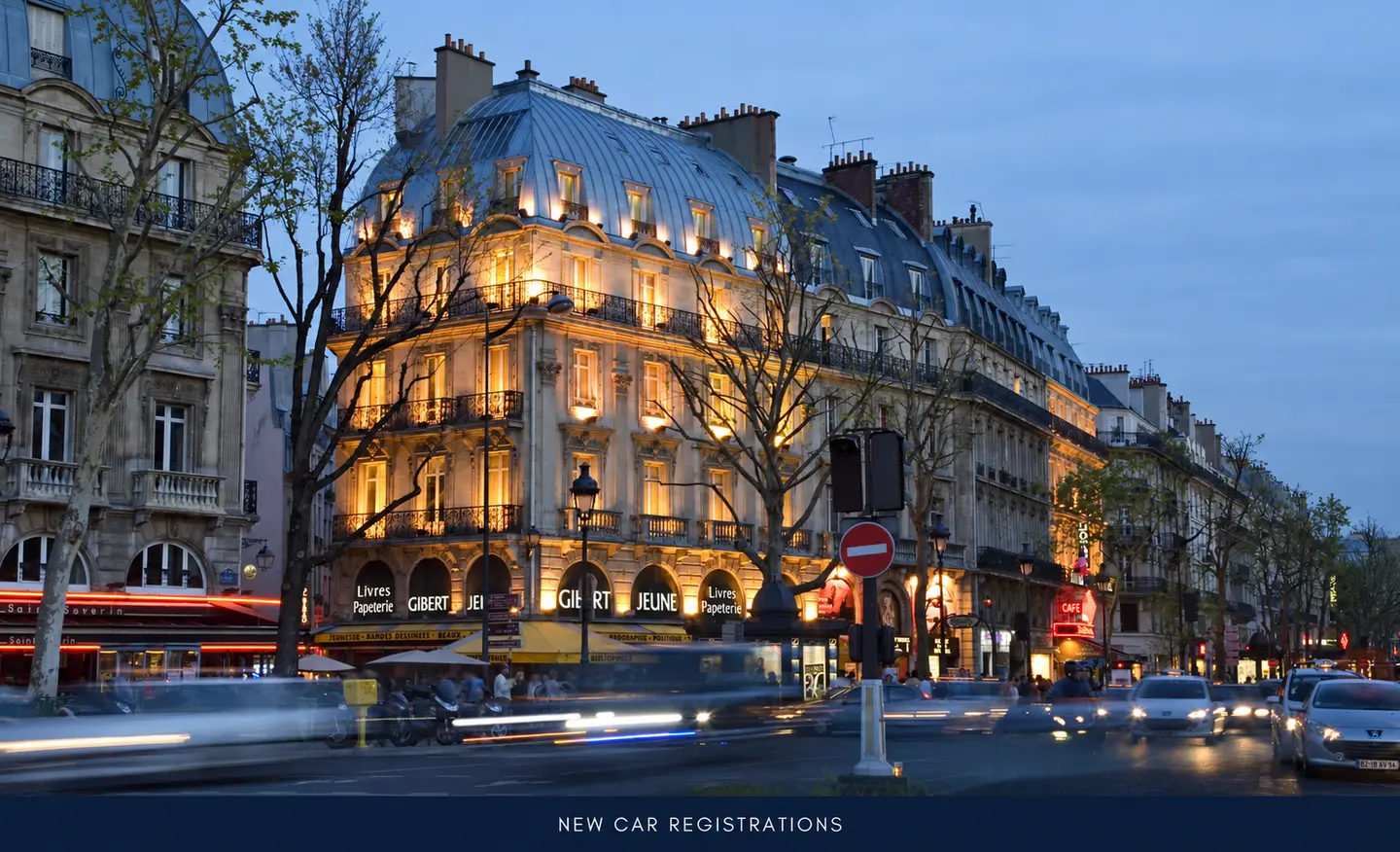 Circulation automobile au crépuscule devant des immeubles parisiens, avec le titre NEW CAR REGISTRATIONS dans une marge inférieure