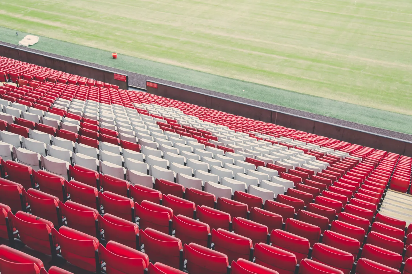 Rows of red and white seats beside the pitch at Anfield football stadium in Liverpool