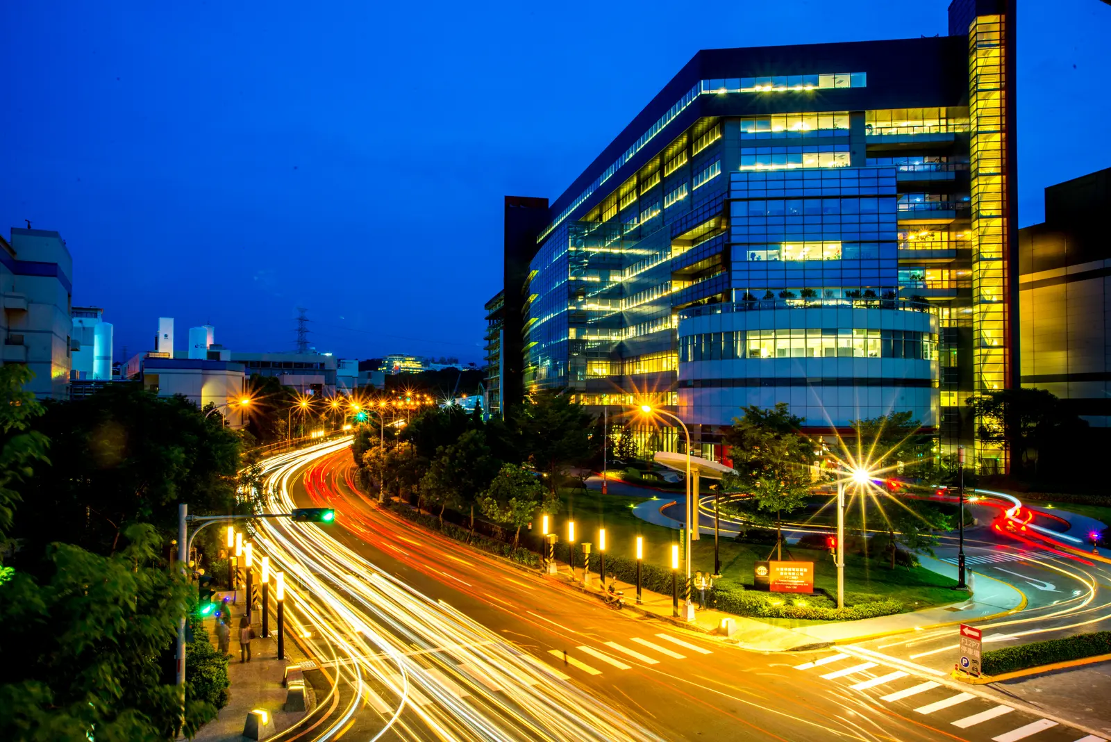 A night view of TSMC Fab 12B in Hsinchu Science Park, Taiwan, with road light trails in the foreground.