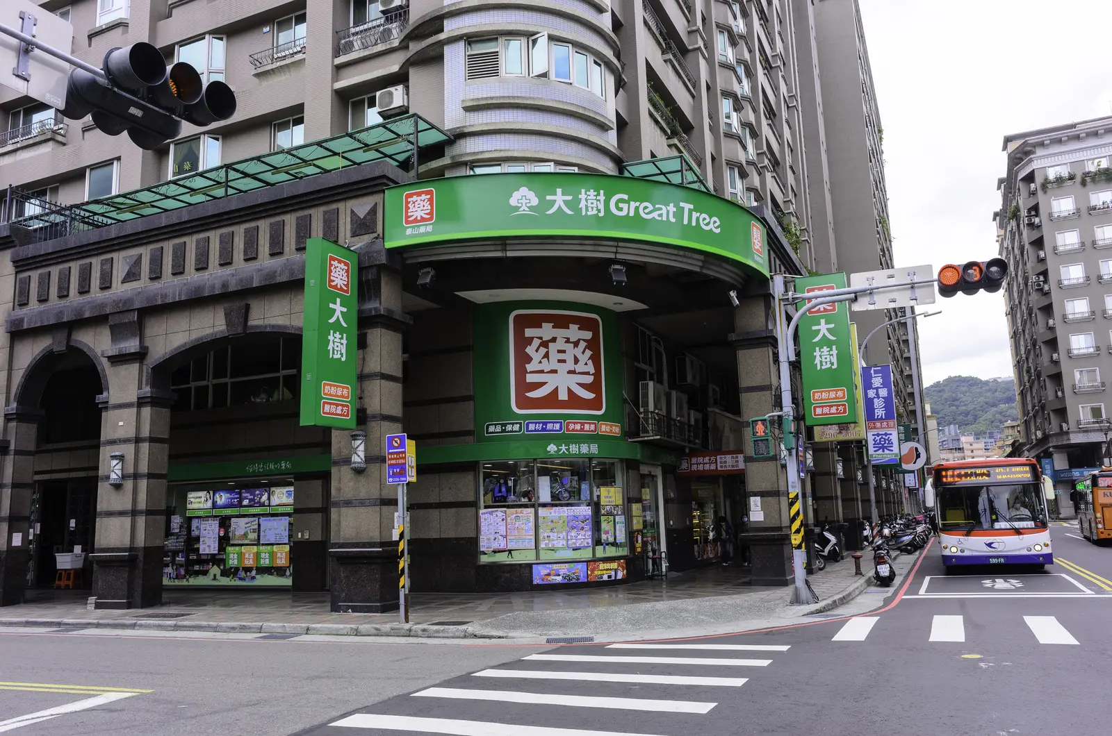 新北市泰山區全興路街角的大樹藥局門市,路口有一輛指南客運公車